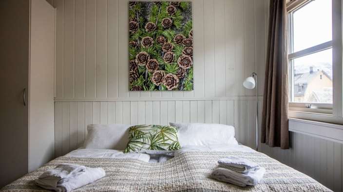 Ein Schlafzimmer mit einem Bett und einem Gemälde an der Wand