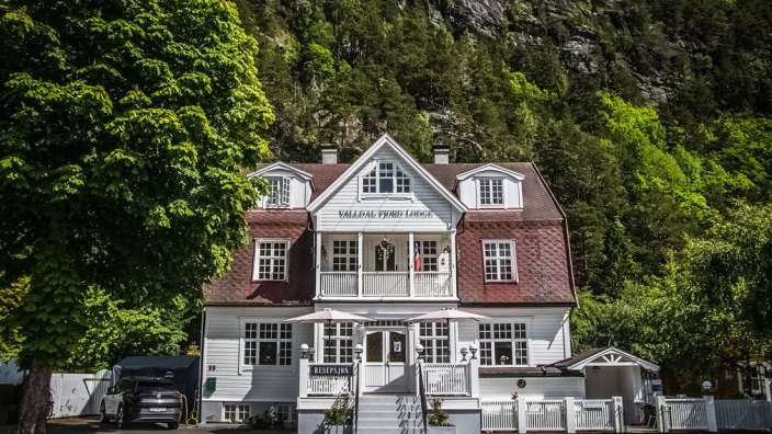 Ein großes weißes Haus mit der Aufschrift valledal fjord lodge darauf