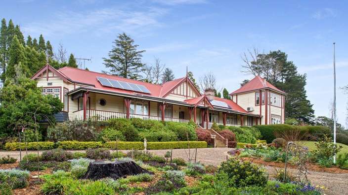 Ein großes weißes Haus mit einem roten Dach und Sonnenkollektoren