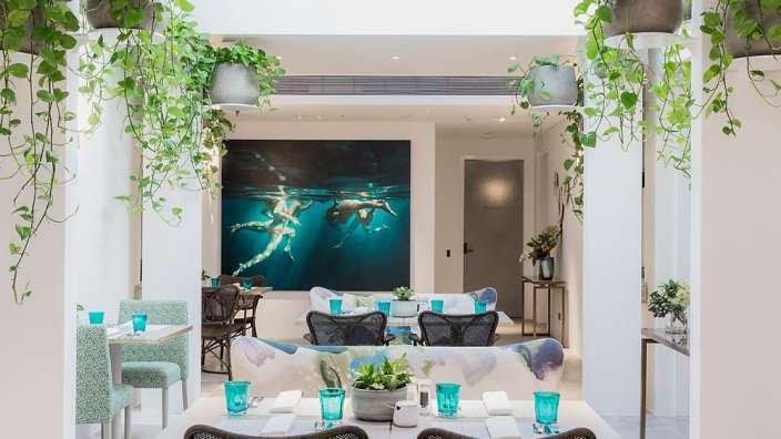 Ein Esszimmer mit blauen Gläsern und einem Gemälde an der Wand