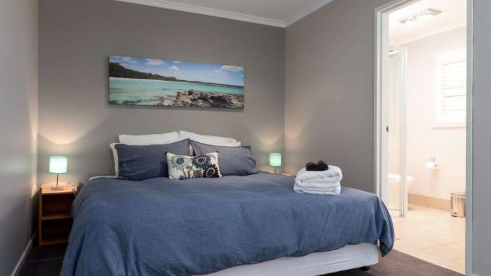 Ein Schlafzimmer mit einem Bett und einem Gemälde an der Wand