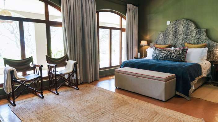 Ein Schlafzimmer mit einem Bett und zwei Stühlen