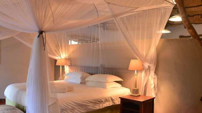 Ein Schlafzimmer mit einem Himmelbett und zwei Lampen