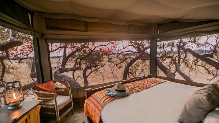 Ein Bett in einem Zelt mit Blick auf die Savanne