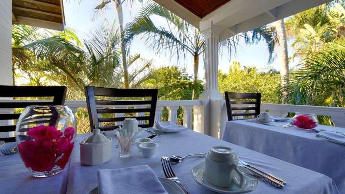 Ein Tisch mit einer Vase mit rosa Blumen darauf