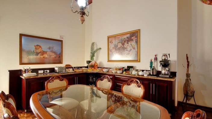 Ein Esszimmer mit einem Tisch und Stühlen und einem Gemälde eines Löwen an der Wand