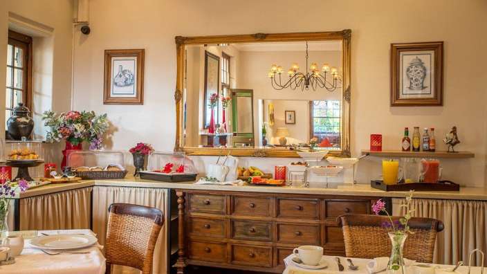 Ein Esszimmer mit einem Tisch und Stühlen und einem Spiegel