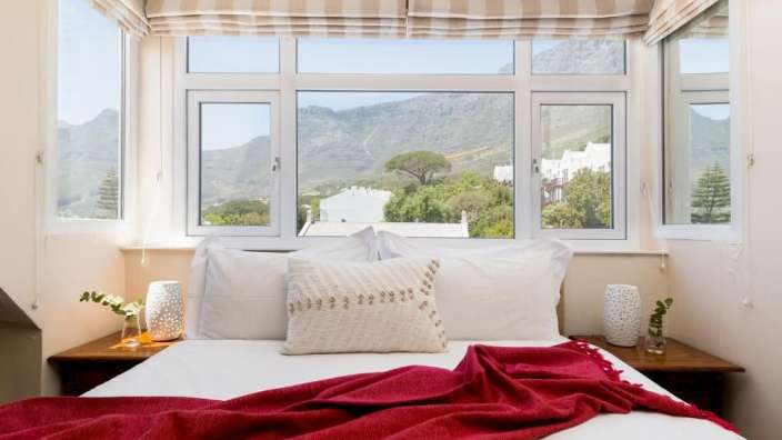 Ein Schlafzimmer mit einem Bett und einem Fenster mit Blick auf die Berge