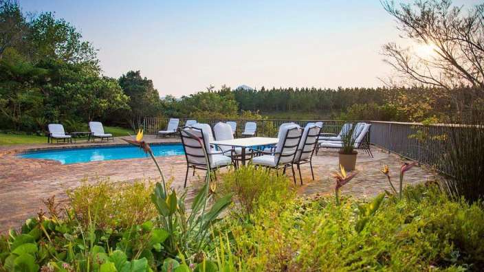 Ein Tisch und Stühle stehen neben einem Swimmingpool