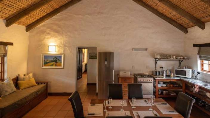 Ein Esszimmer mit einem Tisch und Stühlen und einem Gemälde an der Wand