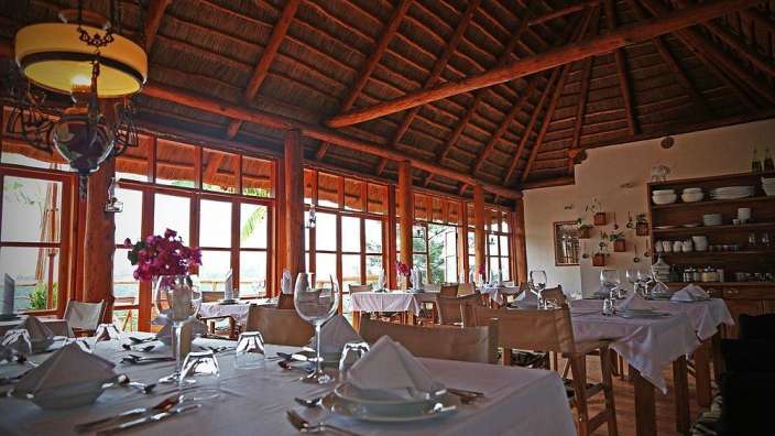 Tische und Stühle in einem Restaurant mit Strohdach