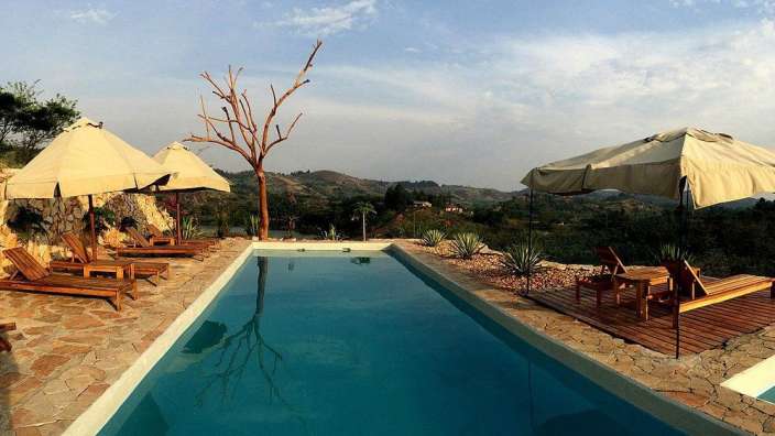 Ein Swimmingpool mit Liegestühlen und Sonnenschirmen umgeben