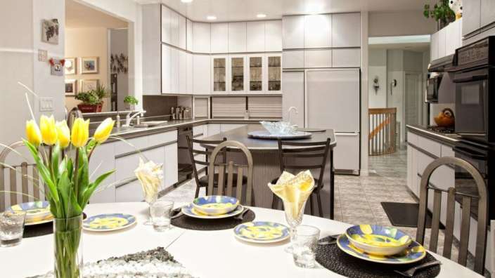 Eine Küche mit einem Tisch und Stühlen und einer Vase mit Blumen darauf