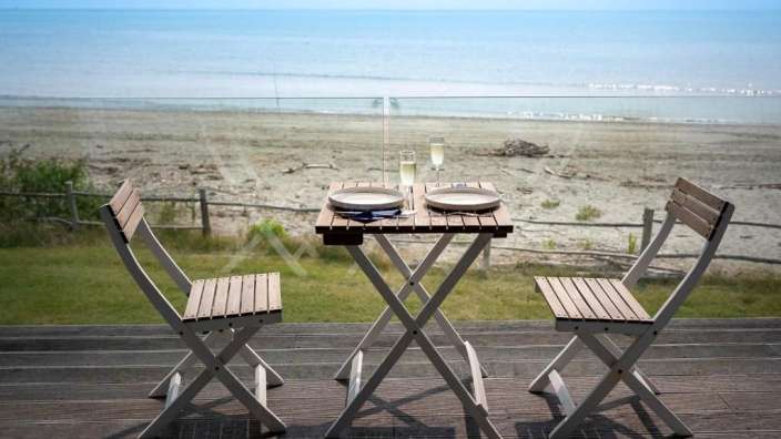 Ein Tisch mit zwei Tellern und zwei Gläsern Champagner auf einem Deck mit Blick auf das Meer