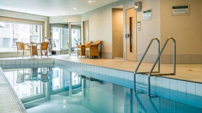 Ein großer Swimmingpool mit einer Treppe , die zu einer Sauna führt