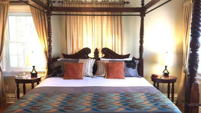 Ein Schlafzimmer mit Himmelbett und zwei Nachttischen