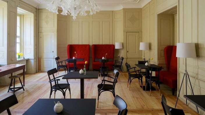 Ein Wohnzimmer mit Tischen und Stühlen und einem Kronleuchter