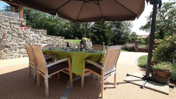Ein Tisch und Stühle unter einem Sonnenschirm auf einer Terrasse