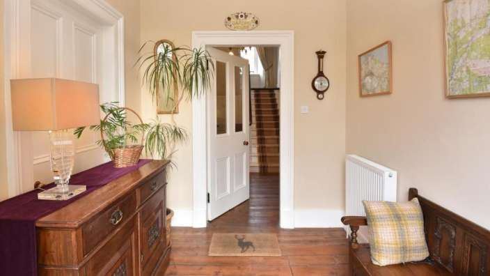 Ein Flur mit einer Bank und einem Tisch mit einer Pflanze darauf