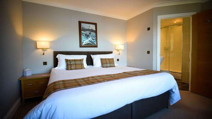 Ein Hotelzimmer mit einem Bett und einem Gemälde an der Wand