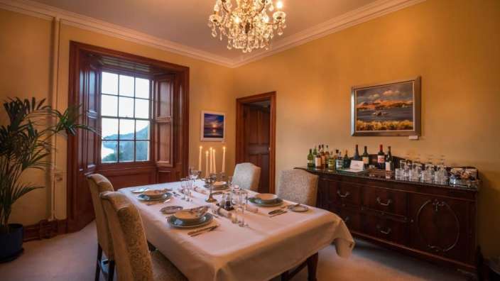 Ein Esszimmer mit einem Tisch und Stühlen und einem Kronleuchter