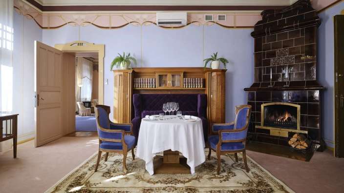 Ein Wohnzimmer mit einem Tisch und Stühlen und einem Kamin