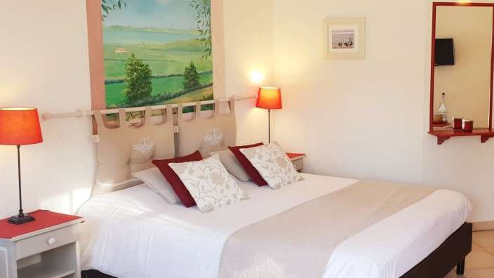 Ein Schlafzimmer mit einem Bett und einem Gemälde an der Wand