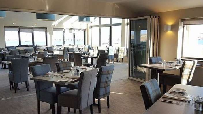 Ein großes Esszimmer mit vielen Tischen und Stühlen