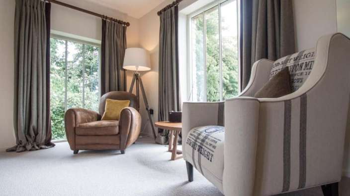 Ein Wohnzimmer mit zwei Stühlen und einer Lampe