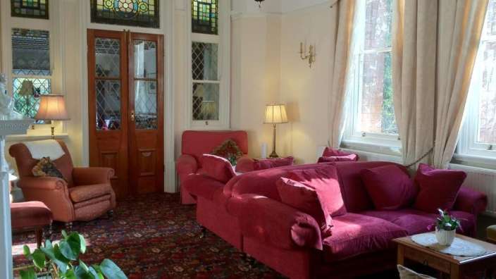 Ein Wohnzimmer mit vielen Möbeln und einem Buntglasfenster