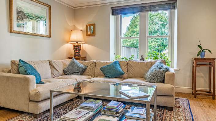 Ein Wohnzimmer mit einem Couchtisch voller Bücher