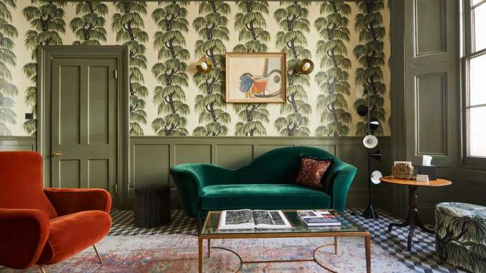 Ein Wohnzimmer mit grünen Wänden und einem grünen Sofa