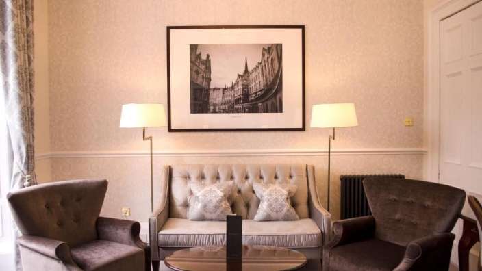 Ein Wohnzimmer mit einer Couch und zwei Stühlen