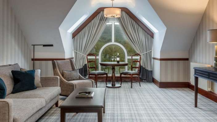 Ein Wohnzimmer mit einem Tisch und Stühlen und einem großen Fenster