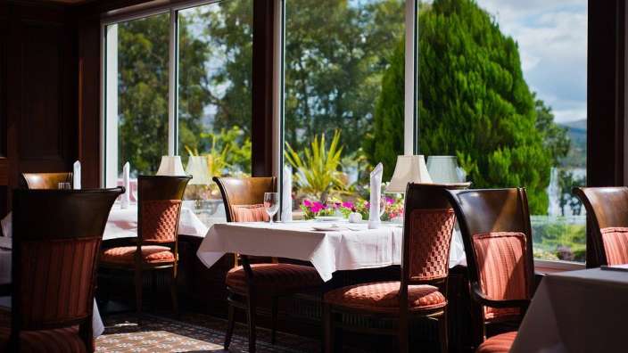 Tische und Stühle in einem Restaurant mit Blick auf einen See