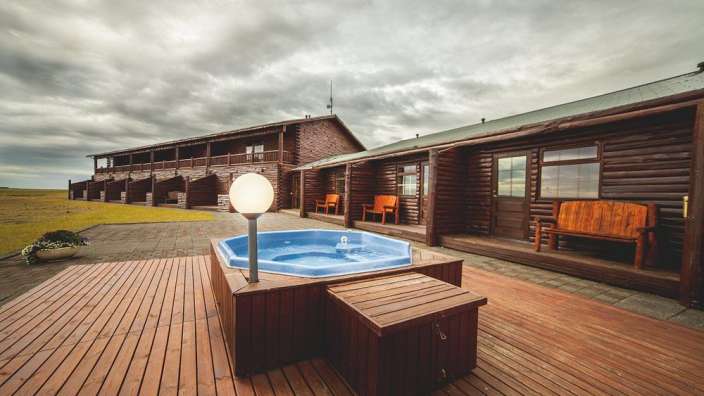 Ein Whirlpool auf einem Holzdeck vor einem Holzhaus
