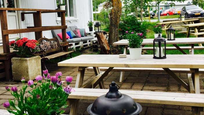Ein Picknicktisch mit lila Blumen und einer Laterne darauf