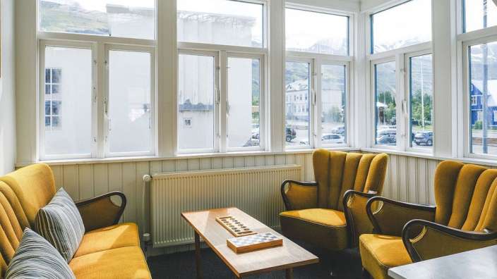 Ein Wohnzimmer mit gelben Möbeln und einem Schachbrett auf einem Tisch