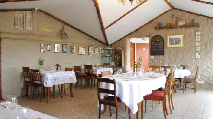 Ein Speisesaal mit weißen Tischen und Stühlen