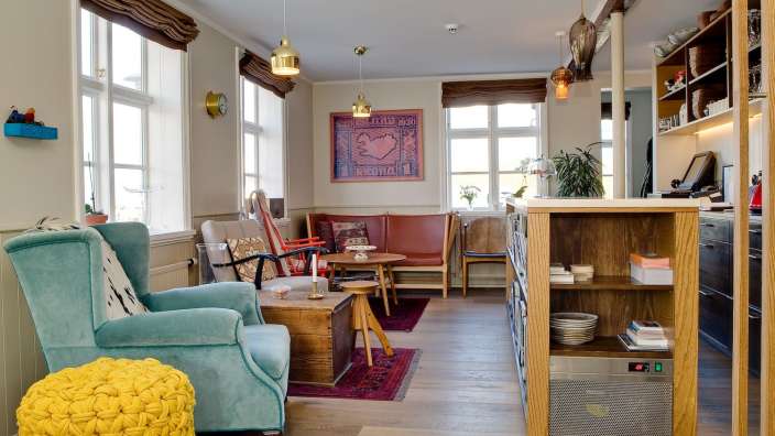 Ein Wohnzimmer mit einem blauen Stuhl und einem gelben Ottoman