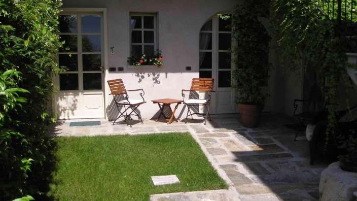 Ein kleiner garten mit einem tisch und zwei stühlen