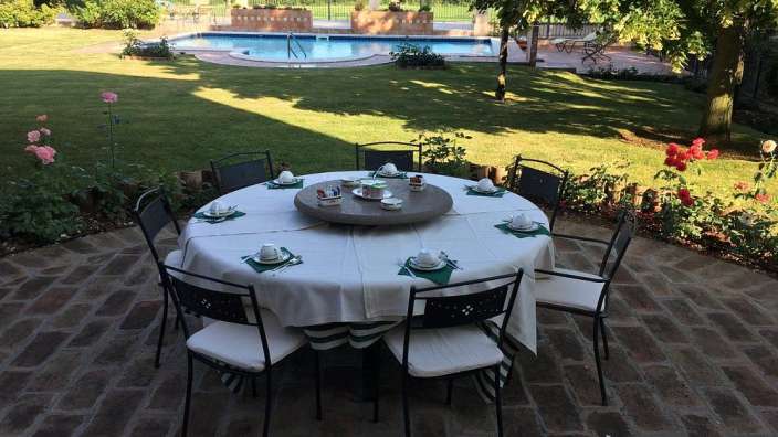 Ein Tisch und Stühle auf einer Terrasse mit einem Pool im Hintergrund