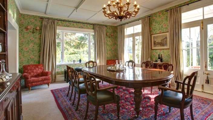 Ein Esszimmer mit einem Tisch und Stühlen und einem Kronleuchter