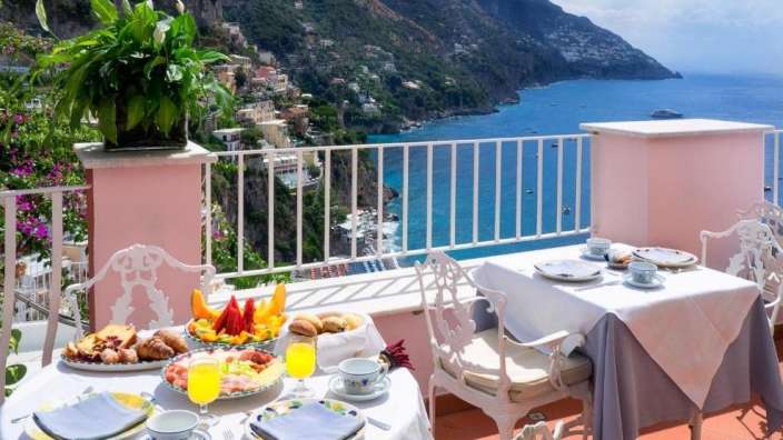 Ein Tisch auf einem Balkon mit einem Teller mit Obst darauf