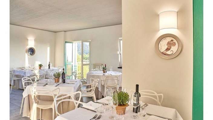 Ein Esszimmer mit Tischen und Stühlen und einem Bild an der Wand