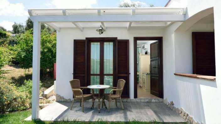 Ein weißes Haus mit einem Tisch und Stühlen darauf