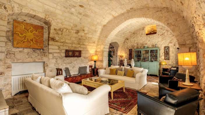 Ein Wohnzimmer mit weißen Möbeln und einem Gemälde an der Wand