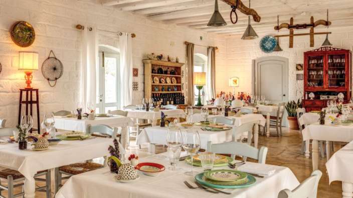 Ein Esszimmer mit vielen Tischen und Stühlen