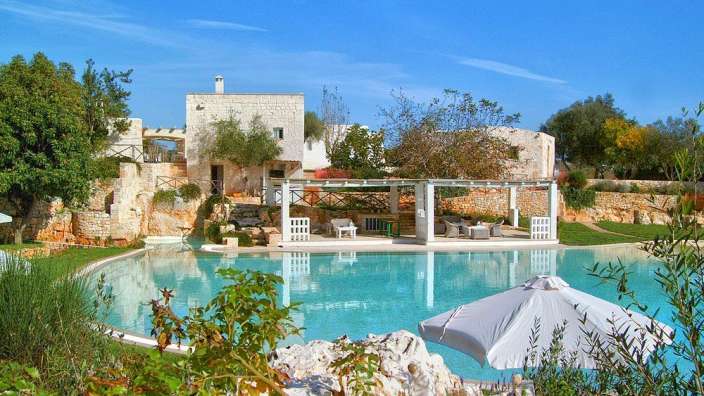 Ein großer Swimmingpool mit einem weißen Regenschirm davor