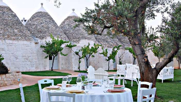 Ein weißer Tisch mit einem weißen Tischtuch und weißen Stühlen